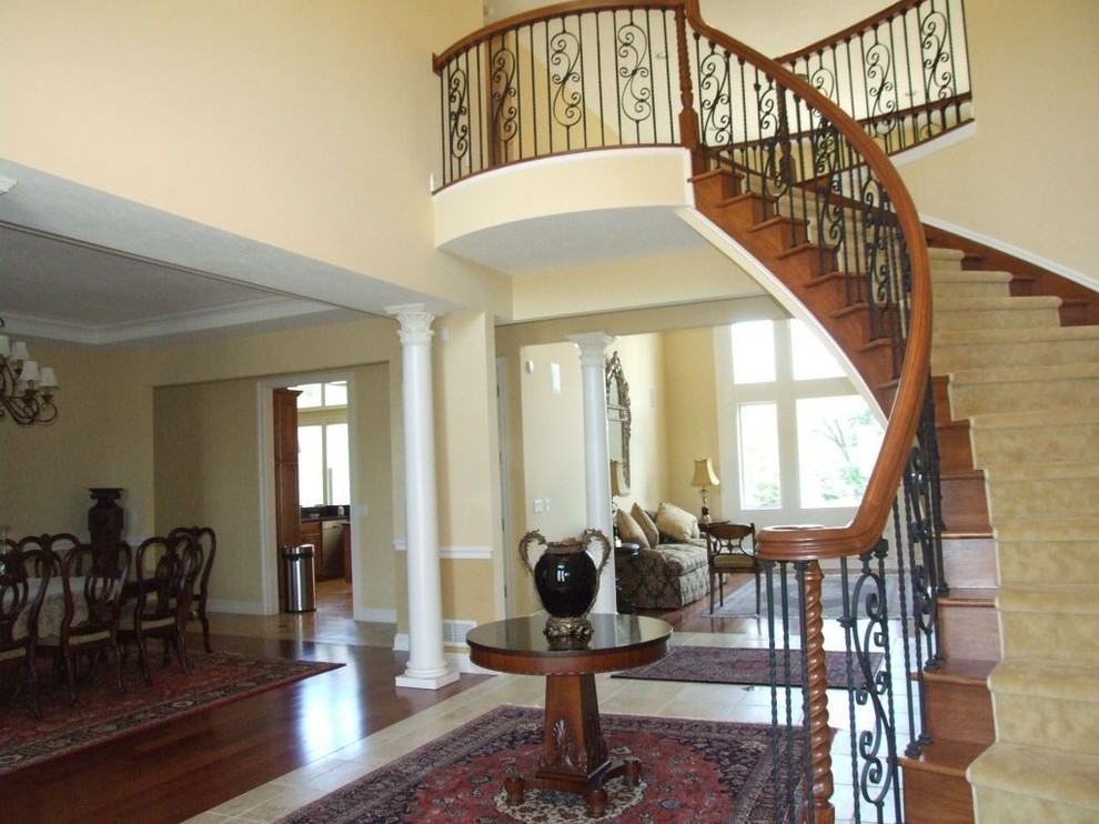 Photo of a large traditional wood curved staircase in Atlanta with wood risers.