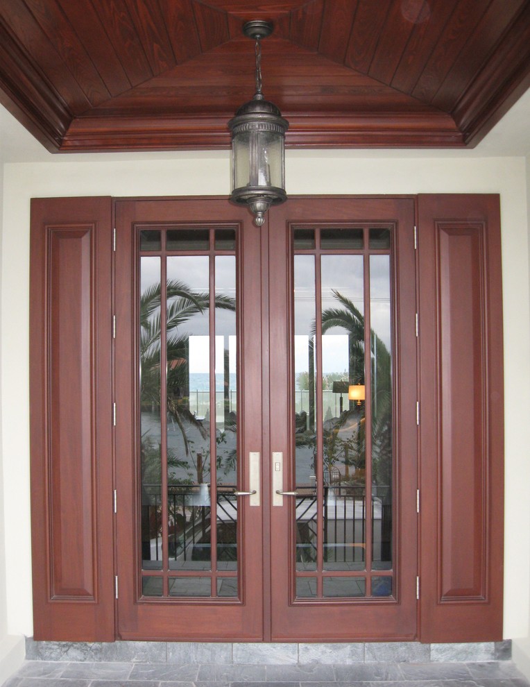 This is an example of a large arts and crafts front door in Miami with white walls, a double front door and a medium wood front door.