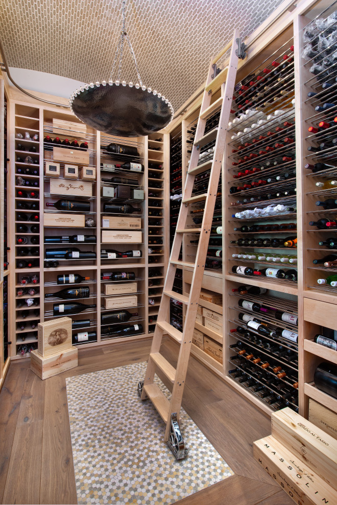 This is an example of a mediterranean wine cellar in Miami with medium hardwood floors and storage racks.