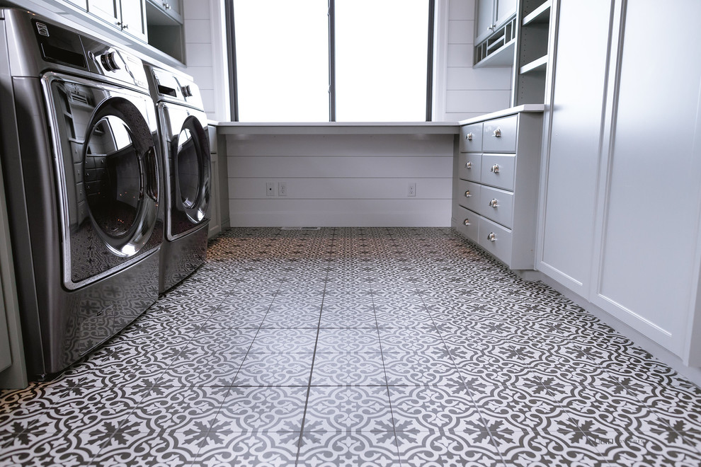 Design ideas for a mid-sized modern laundry room in Seattle with shaker cabinets, grey cabinets, solid surface benchtops, white walls, ceramic floors, a side-by-side washer and dryer and multi-coloured floor.