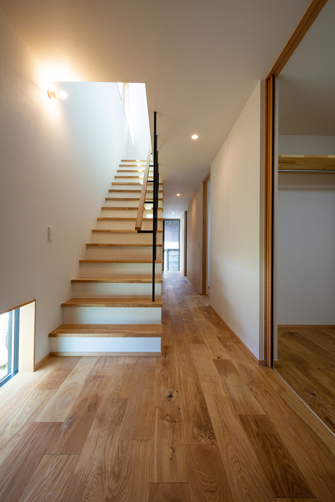 Стильный дизайн: маленькая прямая лестница в скандинавском стиле с деревянными ступенями, металлическими перилами, обоями на стенах и кладовкой или шкафом под ней для на участке и в саду - последний тренд