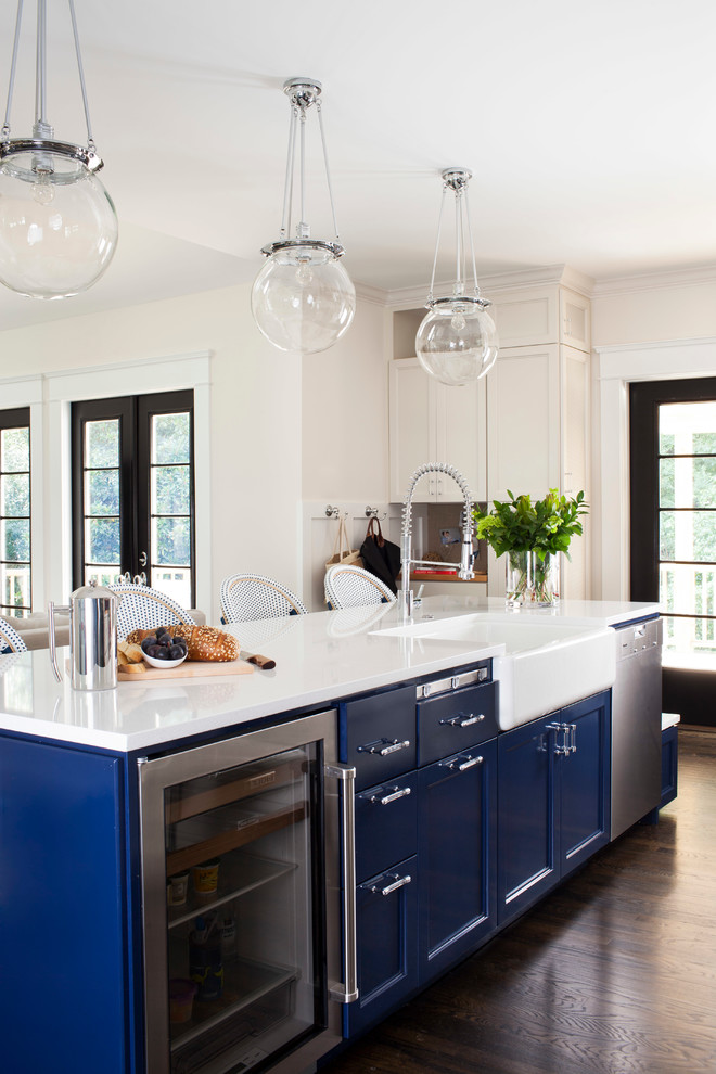 Inspiration for a mid-sized transitional galley dark wood floor open concept kitchen remodel in Atlanta with a farmhouse sink, recessed-panel cabinets, blue cabinets, solid surface countertops, stainless steel appliances and an island