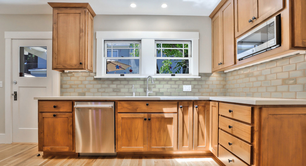 Inspiration for a mid-sized transitional separate kitchen in San Francisco with an undermount sink, shaker cabinets, medium wood cabinets, quartz benchtops, subway tile splashback, stainless steel appliances, medium hardwood floors, brown floor and white benchtop.