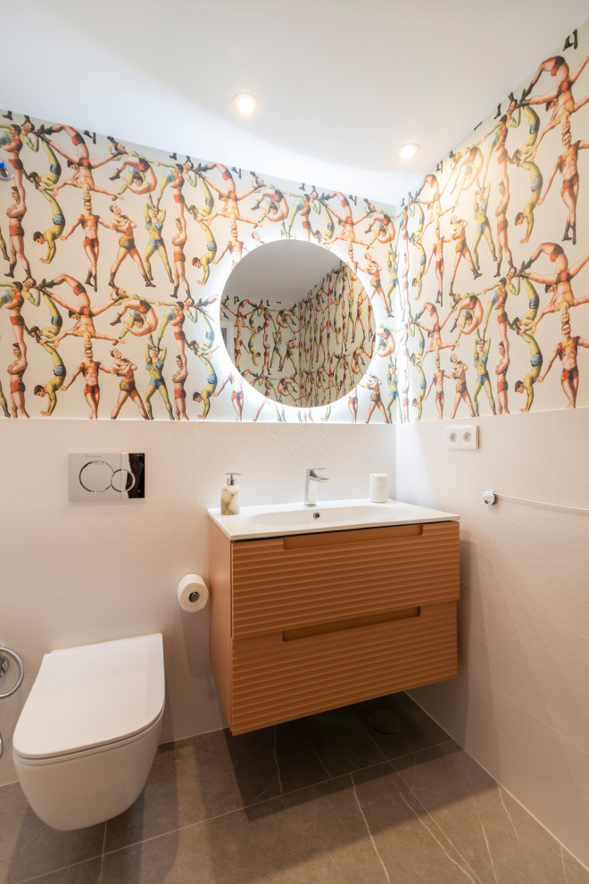 Small contemporary cloakroom in Malaga with raised-panel cabinets, orange cabinets, a wall mounted toilet, white tiles, ceramic tiles, white walls, ceramic flooring, a built-in sink, solid surface worktops, grey floors, white worktops, a floating vanity unit and wallpapered walls.