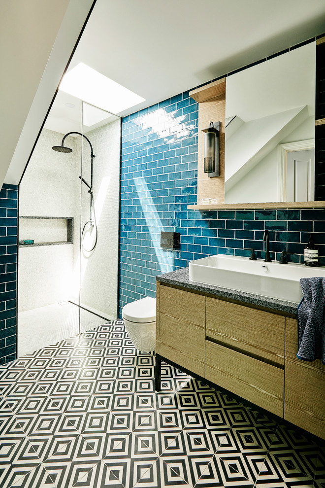 Inspiration for a small contemporary bathroom in Sydney with medium wood cabinets, an alcove shower, a wall-mount toilet, blue tile, ceramic tile, blue walls, cement tiles, a trough sink, terrazzo benchtops, black floor and an open shower.