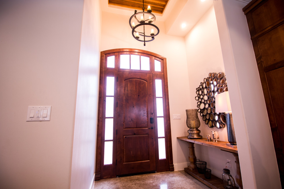 Example of a mid-sized mountain style concrete floor and gray floor foyer design with beige walls and a medium wood front door