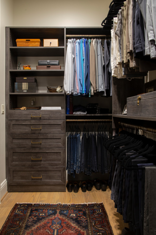 Photo of a medium sized urban walk-in wardrobe for men in Birmingham with recessed-panel cabinets, dark wood cabinets and light hardwood flooring.