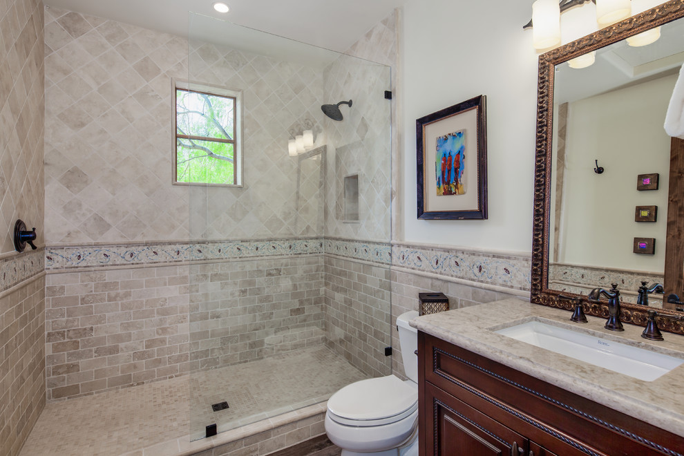Small mediterranean 3/4 bathroom in Phoenix with beaded inset cabinets, dark wood cabinets, an alcove shower, a two-piece toilet, beige tile, travertine, white walls, an undermount sink, granite benchtops and an open shower.