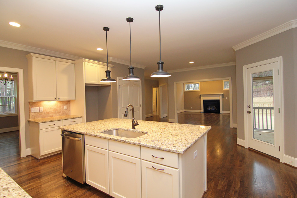 Example of a mid-sized classic u-shaped medium tone wood floor open concept kitchen design in Raleigh with a single-bowl sink, recessed-panel cabinets, white cabinets, granite countertops, beige backsplash, ceramic backsplash, stainless steel appliances and an island