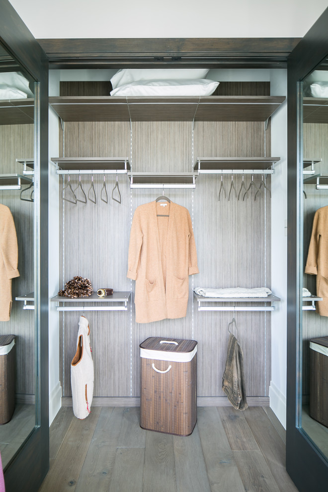 This is an example of a small modern gender-neutral built-in wardrobe in San Diego with flat-panel cabinets, dark wood cabinets, medium hardwood floors and grey floor.