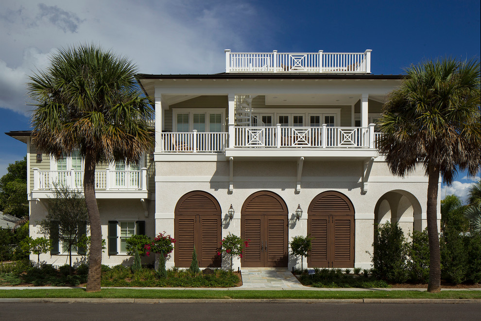 Inspiration for a tropical two-storey beige exterior in Tampa with a hip roof.