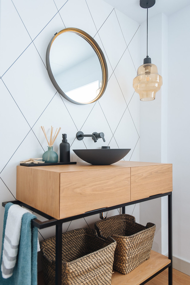 Photo of a contemporary powder room in Other with flat-panel cabinets, medium wood cabinets, white tile, white walls, medium hardwood floors, a vessel sink, wood benchtops, brown floor and brown benchtops.