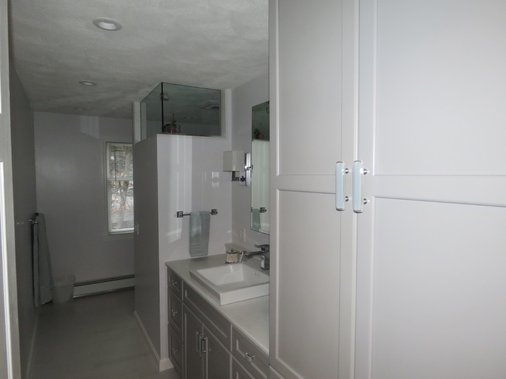 Example of a mid-sized transitional 3/4 porcelain tile alcove shower design in Boston with recessed-panel cabinets, gray cabinets, gray walls, a drop-in sink and marble countertops