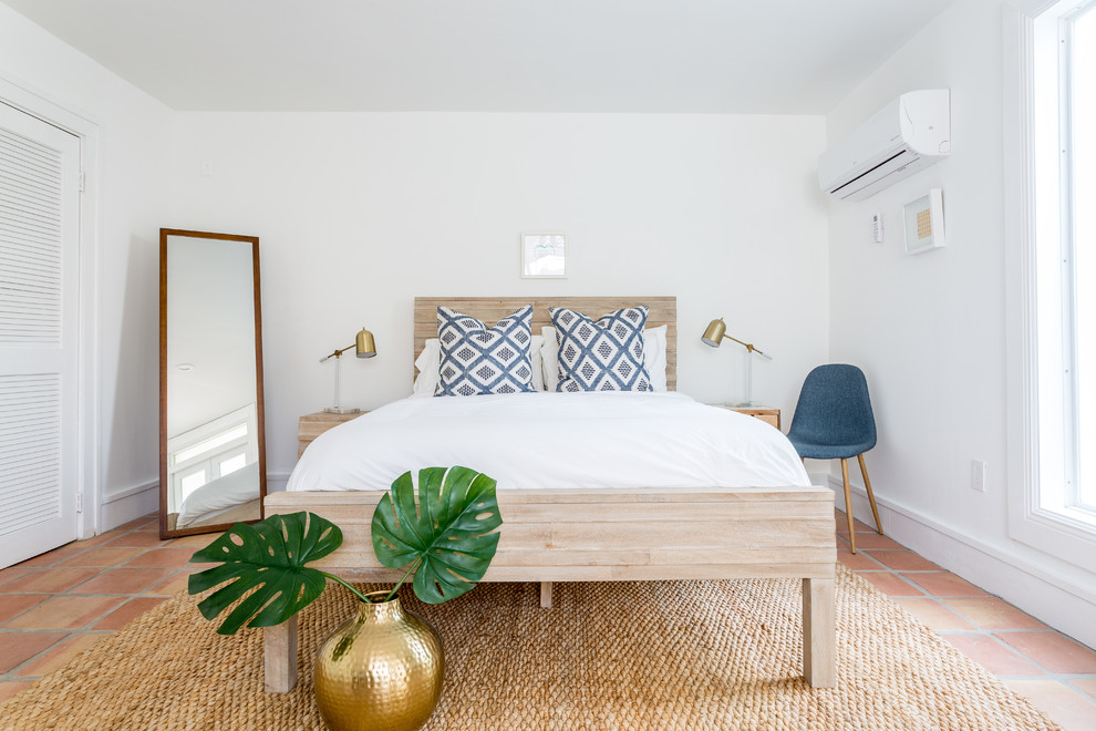 Beach style bedroom in Other with terra-cotta floors.