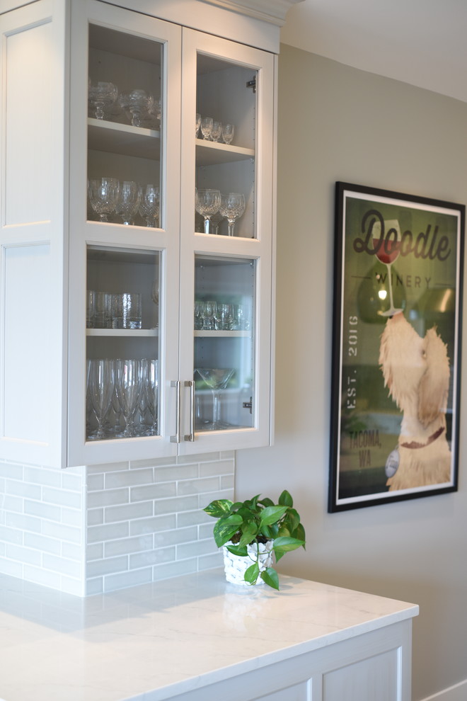 Inspiration for a transitional ceramic tile kitchen remodel in Seattle with shaker cabinets, white cabinets, quartzite countertops, subway tile backsplash, stainless steel appliances, an island and white countertops