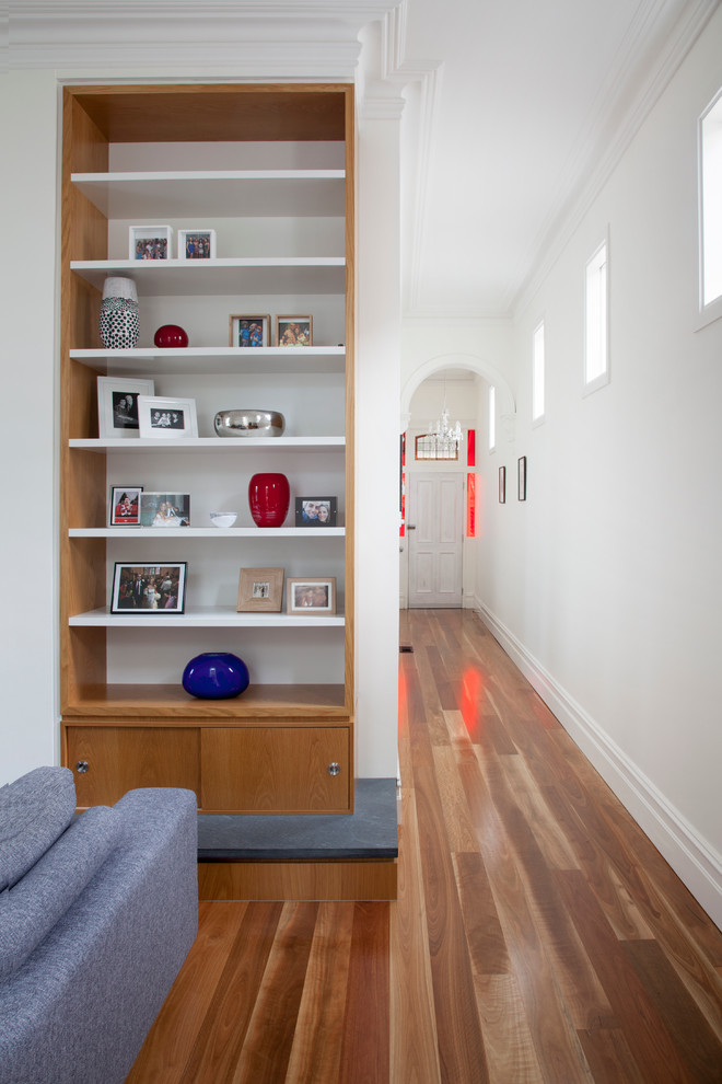 This is an example of a mid-sized scandinavian open concept living room in Melbourne with white walls, medium hardwood floors, a wall-mounted tv and multi-coloured floor.