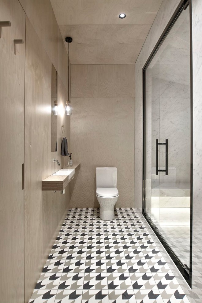 This is an example of a large contemporary bathroom in Saint Petersburg with beige walls, cement tiles, an undermount sink, wood benchtops, multi-coloured floor, a hinged shower door, an alcove shower, a two-piece toilet, open cabinets, marble and grey benchtops.