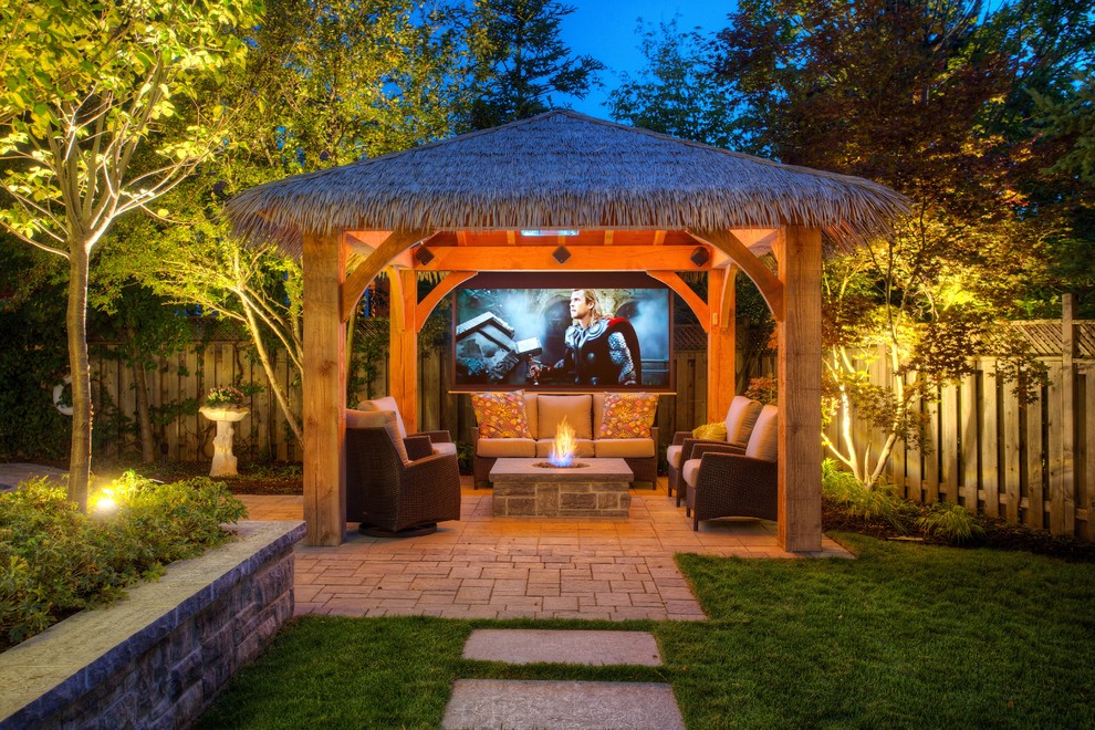 Photo of a tropical patio in Toronto with a fire feature and a gazebo/cabana.