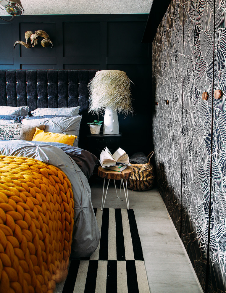 Example of a small eclectic master laminate floor and gray floor bedroom design with black walls and no fireplace