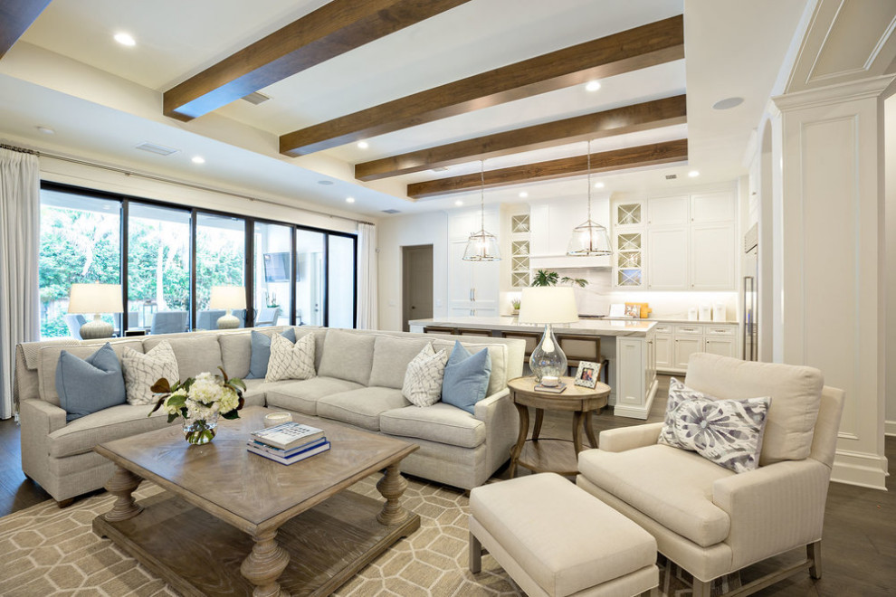 Large transitional open concept family room in Orlando with white walls, medium hardwood floors, a wall-mounted tv, brown floor and exposed beam.