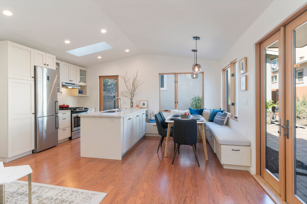 Small arts and crafts u-shaped eat-in kitchen in San Francisco with a single-bowl sink, shaker cabinets, beige cabinets, quartzite benchtops, beige splashback, ceramic splashback, stainless steel appliances, medium hardwood floors, a peninsula and multi-coloured benchtop.