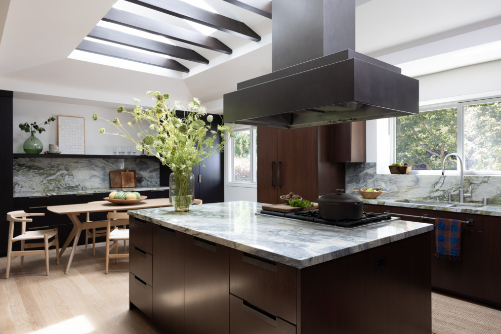 Inspiration for a large contemporary u-shaped eat-in kitchen in San Francisco with an undermount sink, flat-panel cabinets, dark wood cabinets, quartz benchtops, green splashback, engineered quartz splashback, panelled appliances, light hardwood floors, with island, green benchtop, vaulted and beige floor.