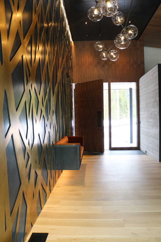 Foyer mit blauer Wandfarbe, hellem Holzboden, Drehtür und Wandpaneelen in Sonstige