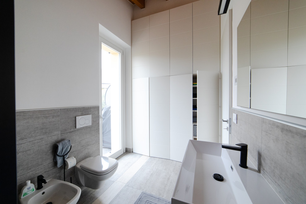 Inspiration for a medium sized modern galley utility room in Milan with a built-in sink, flat-panel cabinets, white cabinets, engineered stone countertops, yellow splashback, porcelain splashback, white walls, porcelain flooring, a stacked washer and dryer, grey floors, white worktops and exposed beams.
