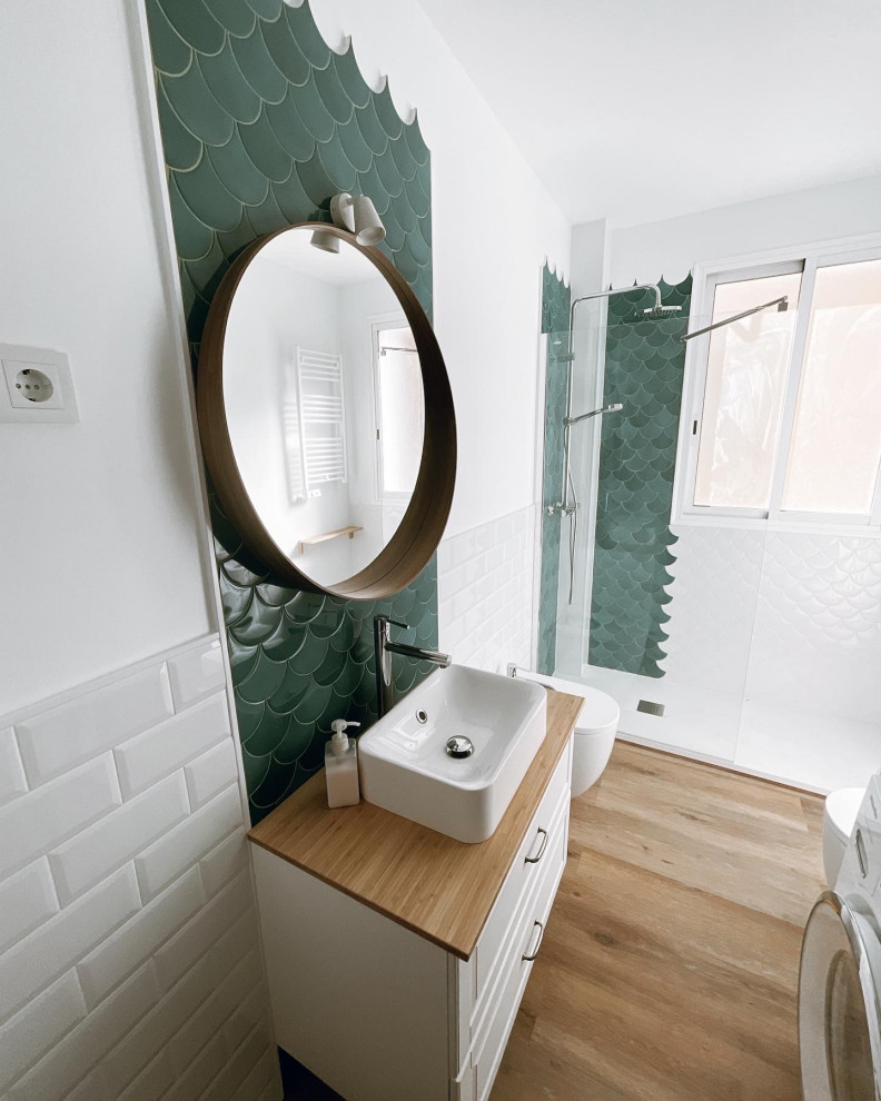 Inredning av ett klassiskt mellanstort brun brunt en-suite badrum, med möbel-liknande, vita skåp, en öppen dusch, en vägghängd toalettstol, blå kakel, keramikplattor, vita väggar, mellanmörkt trägolv, ett väggmonterat handfat, träbänkskiva, brunt golv och med dusch som är öppen