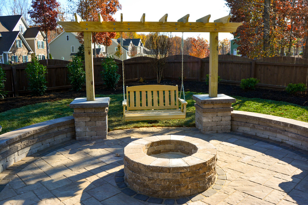 This is an example of a mid-sized traditional backyard patio in Richmond with a fire feature, concrete pavers and no cover.