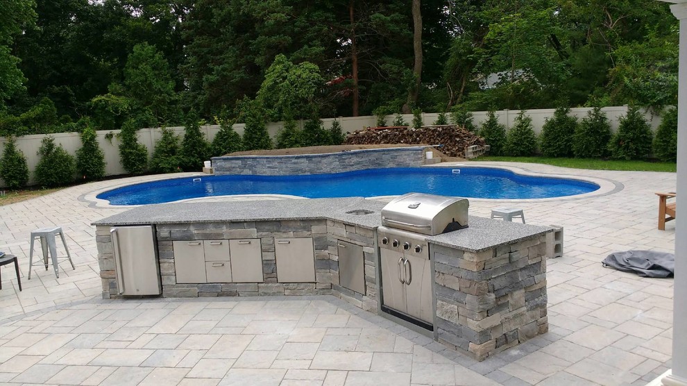 Inspiration for a mid-sized transitional backyard concrete paver and custom-shaped pool remodel in Orange County
