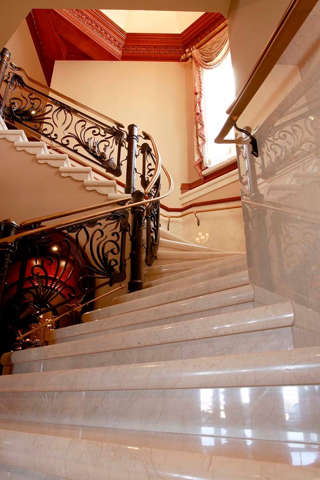 Example of a large classic tile curved staircase design in Orange County with tile risers