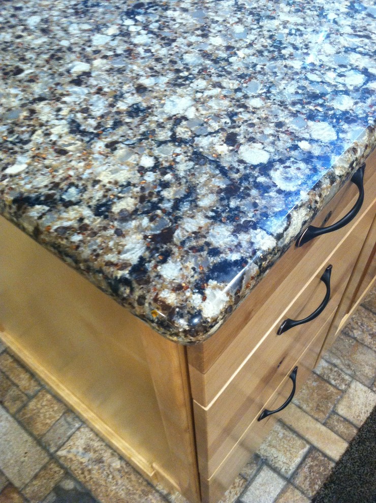 Inspiration for a mid-sized rustic l-shaped ceramic tile eat-in kitchen remodel with an undermount sink, raised-panel cabinets, light wood cabinets, quartz countertops, black appliances and an island