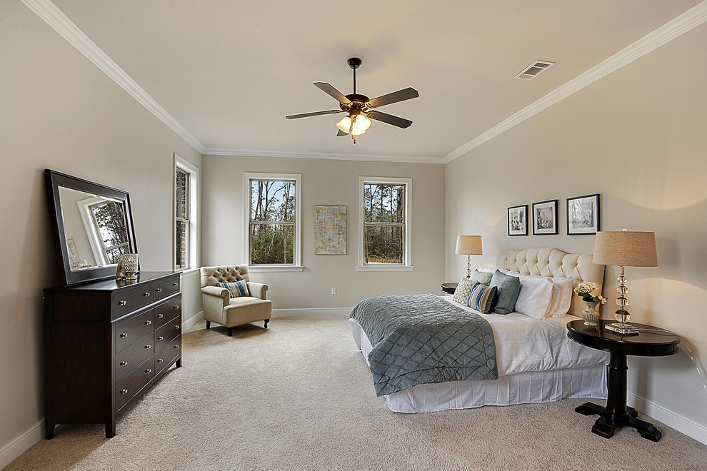 This is an example of a large contemporary master bedroom in New Orleans with beige walls, carpet and no fireplace.