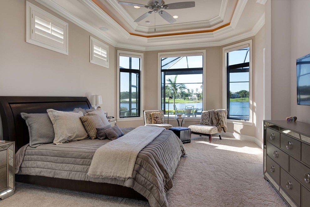This is an example of a mid-sized beach style master bedroom in Other with beige walls and carpet.