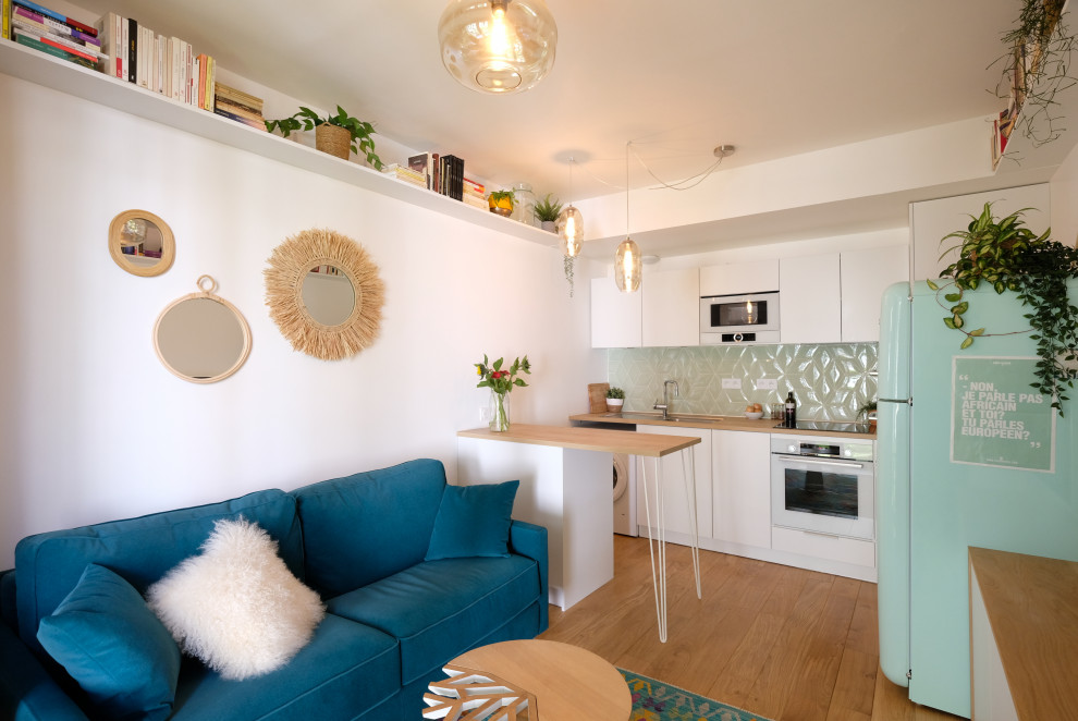 Inspiration för små minimalistiska kök, med en undermonterad diskho, vita skåp, träbänkskiva, grönt stänkskydd, stänkskydd i keramik, vita vitvaror, ljust trägolv och en köksö