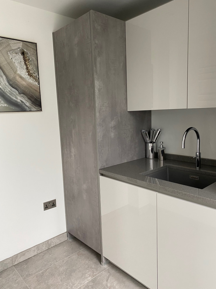 Large contemporary galley utility room in Manchester with a submerged sink, flat-panel cabinets, grey cabinets, quartz worktops, porcelain flooring, grey floors and grey worktops.