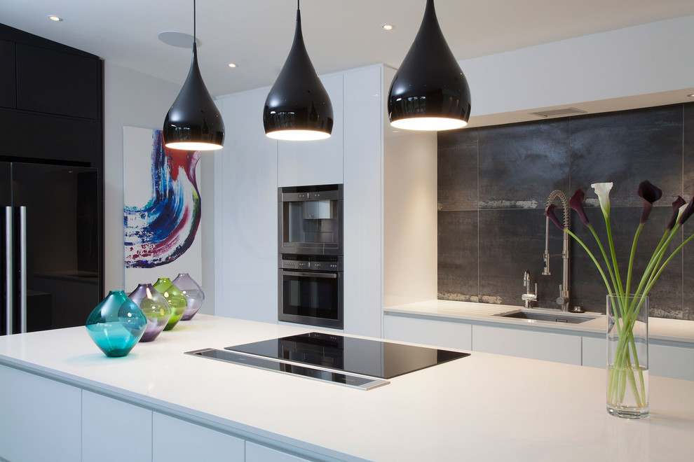 Photo of a mid-sized contemporary l-shaped kitchen pantry in London with a single-bowl sink, flat-panel cabinets, white cabinets, black splashback, ceramic splashback, stainless steel appliances, ceramic floors and a peninsula.