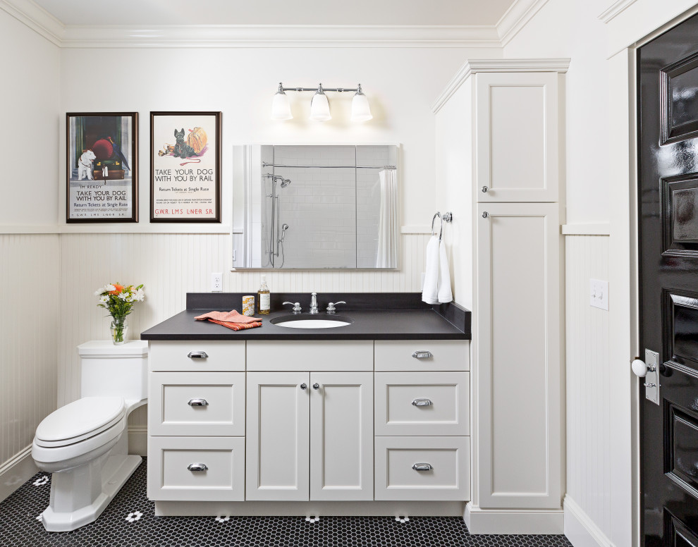This is an example of a transitional bathroom in Detroit with recessed-panel cabinets, white cabinets, white walls, mosaic tile floors, an undermount sink, black floor, black benchtops and decorative wall panelling.