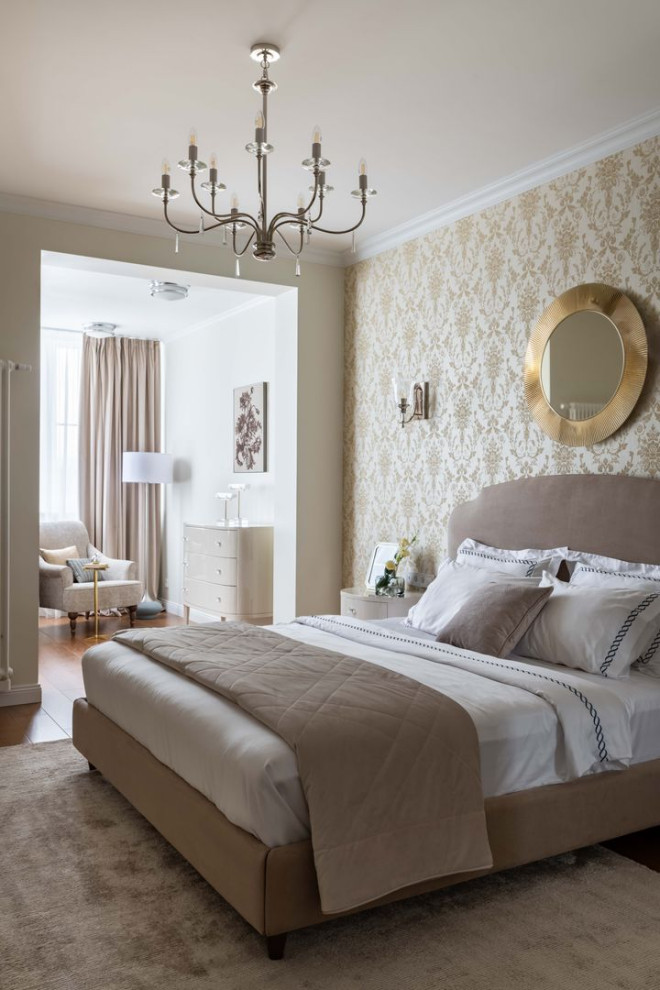 Modelo de dormitorio clásico renovado con paredes beige, suelo de madera en tonos medios, suelo marrón y papel pintado