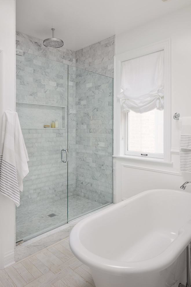 Design ideas for a mid-sized transitional master bathroom in Chicago with beaded inset cabinets, white cabinets, a freestanding tub, an alcove shower, a two-piece toilet, white tile, marble, white walls, light hardwood floors, an undermount sink, marble benchtops, beige floor and a hinged shower door.