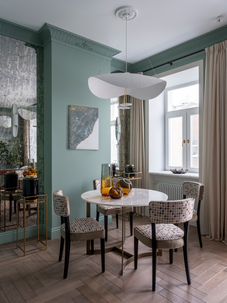 Photo of a transitional dining room in Moscow with green walls, medium hardwood floors and brown floor.