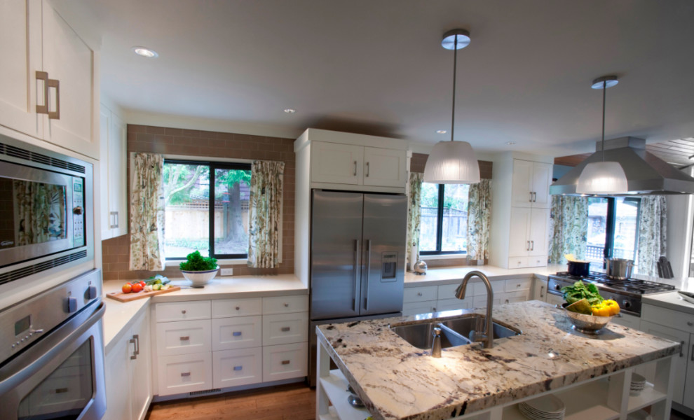 Inspiration for a mid-sized transitional u-shaped medium tone wood floor and brown floor eat-in kitchen remodel in Seattle with a double-bowl sink, shaker cabinets, white cabinets, quartz countertops, brown backsplash, subway tile backsplash, stainless steel appliances and an island