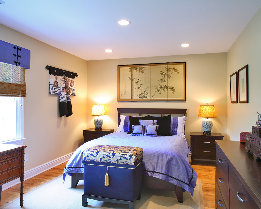Asian bedroom in Other with beige walls and medium hardwood floors.