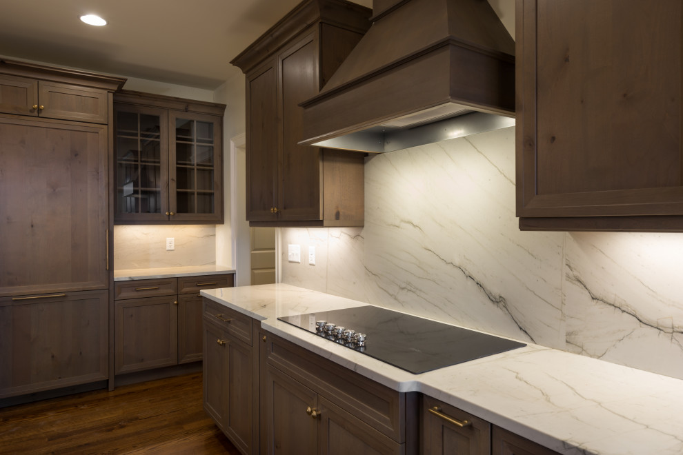 Mid-sized transitional single-wall dark wood floor and brown floor eat-in kitchen photo with a single-bowl sink, shaker cabinets, dark wood cabinets, granite countertops, white backsplash, stone slab backsplash, paneled appliances, an island and white countertops