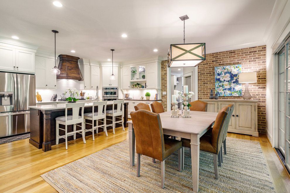 Inspiration for a large transitional u-shaped medium tone wood floor and brown floor eat-in kitchen remodel with a farmhouse sink, recessed-panel cabinets, white cabinets, quartz countertops, white backsplash, ceramic backsplash, stainless steel appliances, an island and white countertops