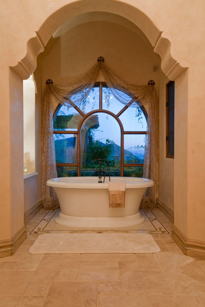 Design ideas for an expansive mediterranean master bathroom in Phoenix with furniture-like cabinets, brown cabinets, a freestanding tub, an alcove shower, a one-piece toilet, multi-coloured tile, mirror tile, multi-coloured walls, travertine floors, a vessel sink, granite benchtops, multi-coloured floor, an open shower and multi-coloured benchtops.