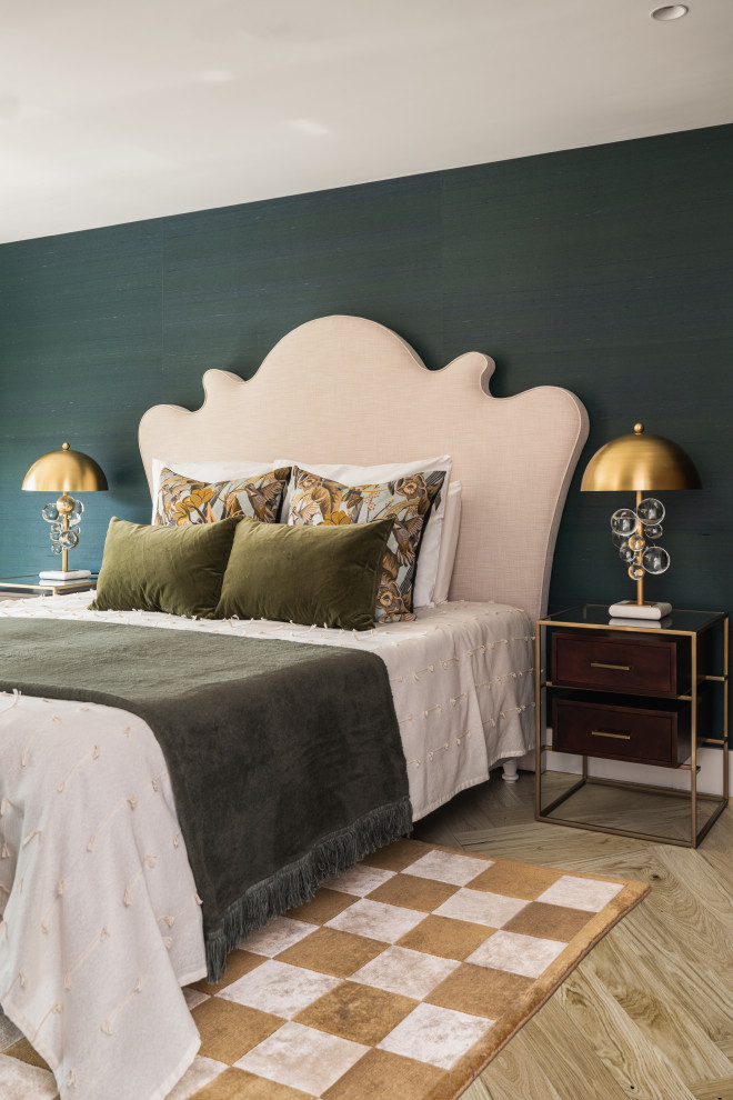 Cette image montre une grande chambre parentale design avec un mur vert et un sol en bois brun.
