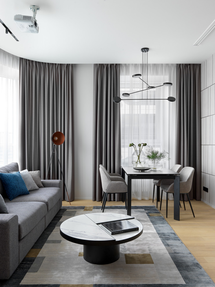 Ispirazione per un soggiorno minimal di medie dimensioni con pareti grigie, parquet chiaro, TV a parete e pavimento beige