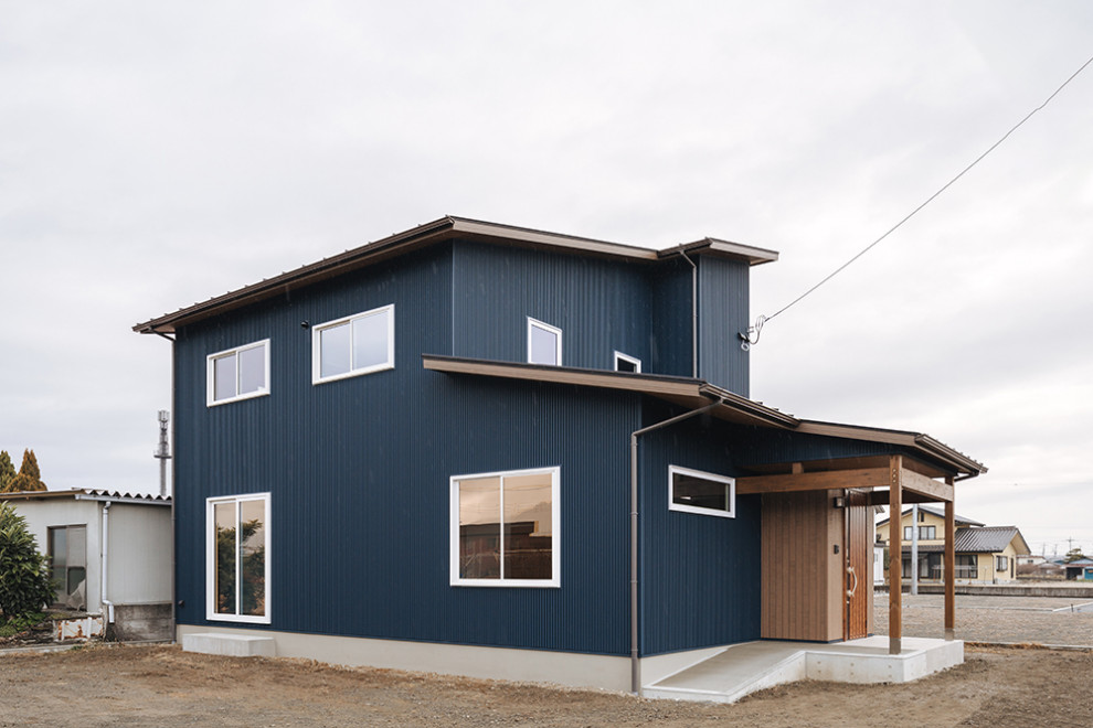 На фото: двухэтажный, синий частный загородный дом среднего размера с комбинированной облицовкой и отделкой доской с нащельником с